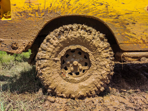 Mud-covered off-road vehicle wheel after crossing an extreme muddy track, highlighting rugged adventure driving, challenging terrain conditions, and the demanding nature of off-road activities.