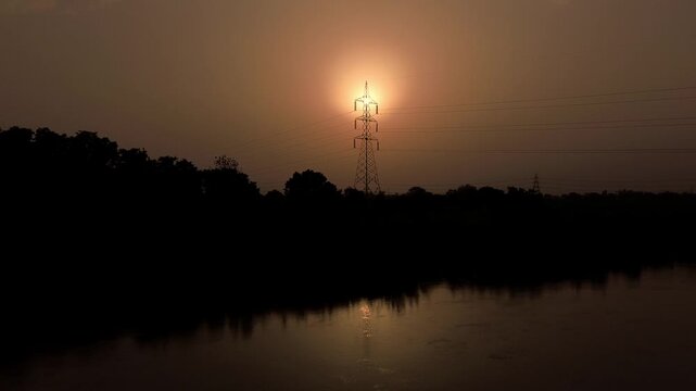 sun set through electric  tower 