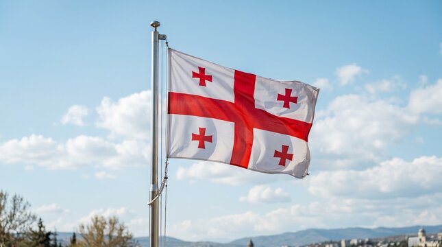 Georgian flag waving in the breeze against a blue sky