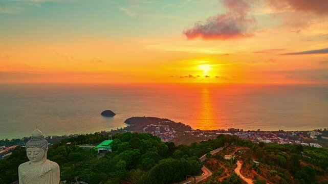 Stunning aerial view of the Phuket Big Buddha during sunset, overlooking the Andaman Sea under dramatic evening clouds. Time lapse stunning sunset behind Phuket big buddha landmarks on the island.