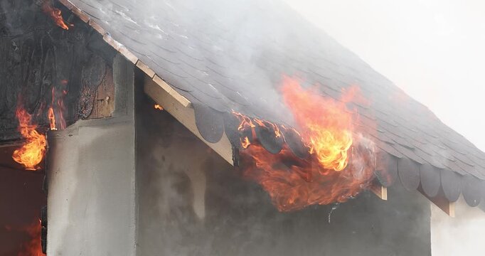 A 4K slow motion movie with a miniature house burns in a controlled manner to observe the behavior of different materials and untreated wood against fires.