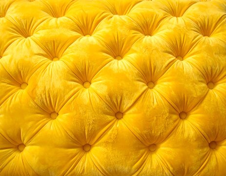 A close-up of a vibrant yellow tufted upholstery with button-tufted design
