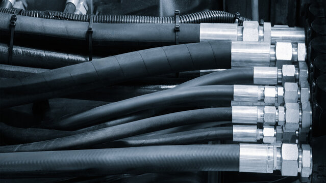 Bundle of pipes connected to industrial hydraulic pneumatic machine, tech industrial technology background