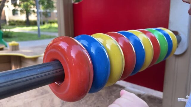 Child learning counting with colorful abacus on playground