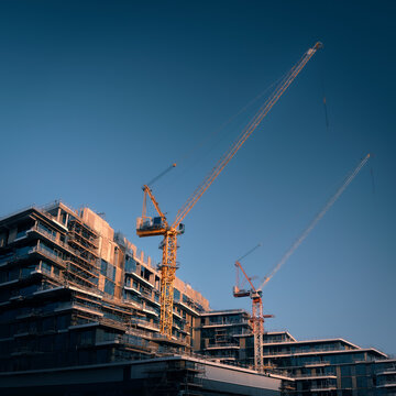 Construction site of modern residential buildings in scaffolding with cranes at day, Abu Dhabi