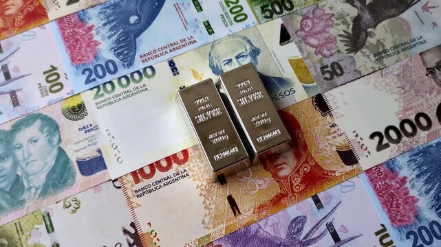 A silver bar, white metal against a backdrop of Argentine money, as a concept for the sales market. A silver bar as a background for your design
