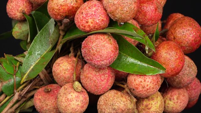 Detailed macro of a fresh lychee fruit bunch with water drops