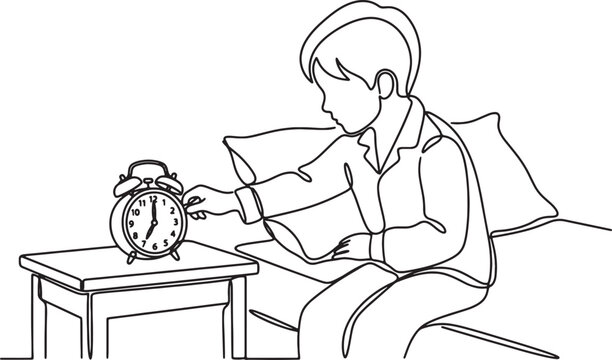 Young boy waking up and turning off alarm clock in the morning