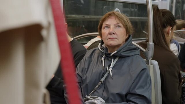 Senior woman passenger riding underground subway train inside public transport carriage. Elderly female citizen using urban transit for city travel and daily metropolitan commuting lifestyle.