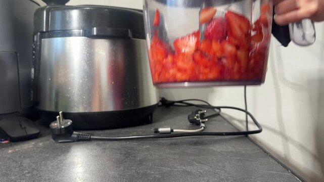 Blending fresh ripe red strawberries in a kitchen blender until smooth puree, thick sweet aroma, vibrant red color, quick easy homemade delicious breakfast treat, candid authentic life moment.