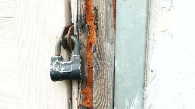 Old metal door latch with rust corrosion and worn surface showing aging materials and industrial deterioration