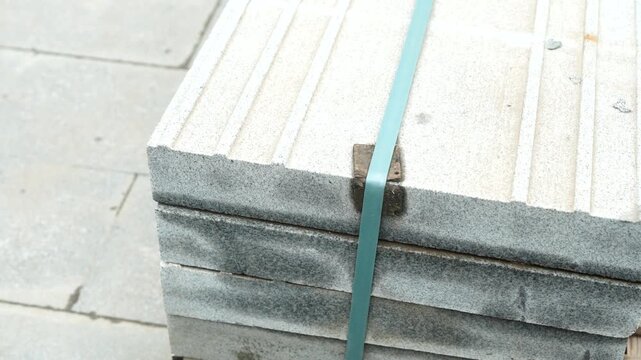 Stacked concrete slabs secured with plastic straps representing construction materials, industrial supply and infrastructure development