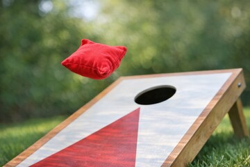 Naklejka premium A bean bag toss game with a red hat