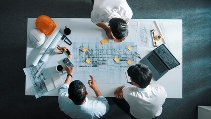 Top down aerial view of interior designer writing at sticky note while planning design with...