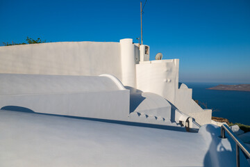 Sunlit Greek island architecture with domed rooftops and blue horizon, minimalist travel background. © Andrei Tomas