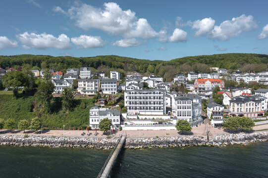 Drone view over the harbor district of Sassnitz, Mecklenburg-Vorpommern, Germany, with port structures, waterfront houses, sea, and coastal urban landscape in daylight.