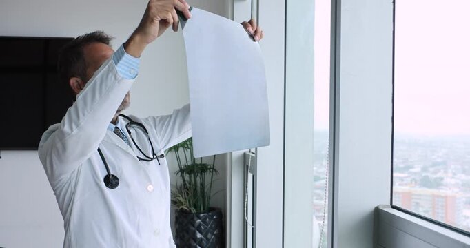 Senior latin man doctor specialist looking at an x ray scan at office or hospital in Mexico Latin America