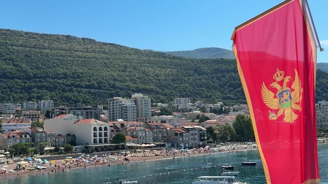 Montenegro flag above Adriatic sea in Petrovac Budva riviera.