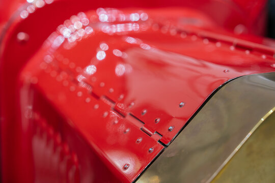 A detailed close up of the hood and bodywork of a historic automobile. The image highlights classic automotive craftsmanship and restoration quality.