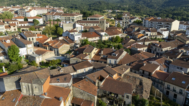 Aerial view of the historic town of Allariz featuring traditional stone houses with terracotta tiled roofs nestled in the green landscape of Allariz, Province of Ourense, Spain.
