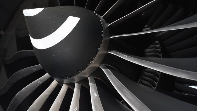 Genx turbine engine compressor blades turning slowly in the wind. Commercial airplane jet engine.