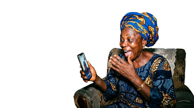 Joyful senior African woman in traditional dress expressing extreme excitement during a smartphone video call.