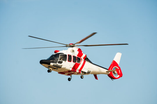 Red and White Emergency Helicopter Airborne in Clear Blue Sky, The Concept of Medical Evacuation