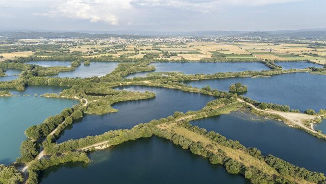 Aerial view of Lagoa da Lontra featuring interconnected ponds surrounded by lush vegetation and rural fields in Sandias, Ourense, Spain.
