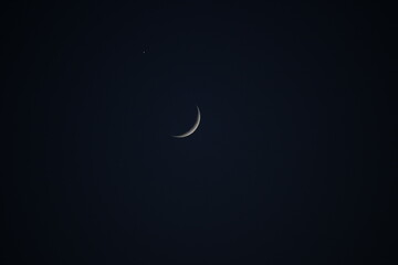 Conjunción astronómica de la luna creciente y el planeta Venus en el cielo nocturno oscuro. Fondo minimalista de astronomía y espacio. © José Antonio