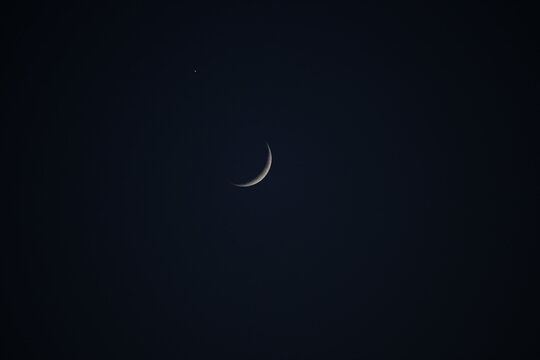 Conjunci&oacute;n astron&oacute;mica de la luna creciente y el planeta Venus en el cielo nocturno oscuro. Fondo minimalista de astronom&iacute;a y espacio.