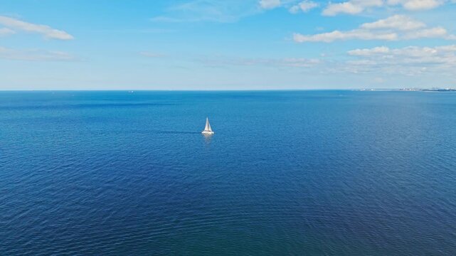 Minimalist aerial view of sailboat in open Baltic Sea with vast blue water