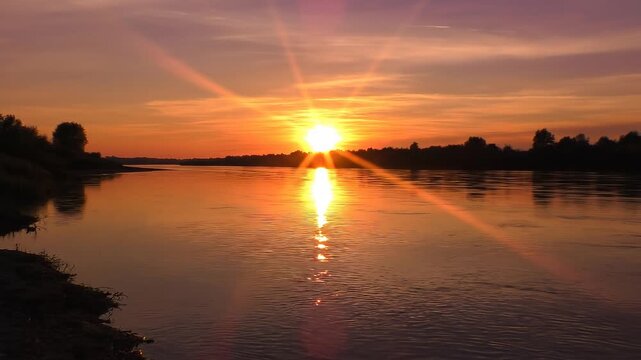 Serene golden sunset casting long shimmering path on water POV from opposite riverbank long shot