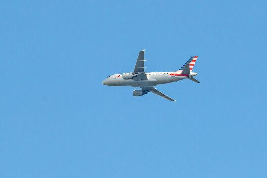 American Airlines commercial passenger jet Airbus 319 plane isolated against a blue sky