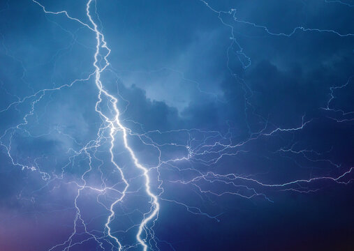 Fork lightning striking down during summer storm at night