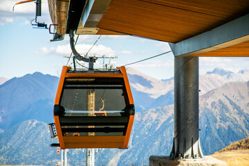 Orange cable car gondola at mountain station in Arkhyz resort. © Lena May