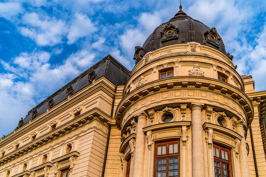 Monumental historic building with dark dome and Corinthian columns in golden light against blue sky, institutional architecture photography.