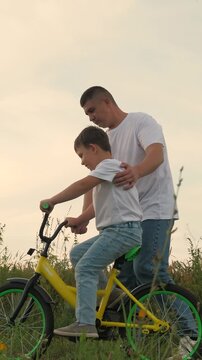 boy beloved father learning ride bike, family bike ride outdoors, man child kid boy outdoors learning ride bike park, cheerful people riding bike green grass, little son boy schoolboy dad park, family