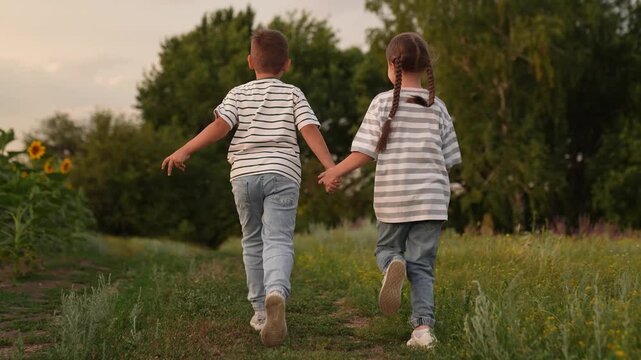 girl boy children run sunset, Happy children running in nature, kids holding hands in a field, childhood friendship outdoors, summer adventure for kids, siblings enjoying a walk, playful kids in