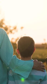 woman mother hugs boy son sunset, woman hugs child kid in nature, people outdoors, maternal care children love, happy family, long lasting memories, together facing future, walking together outside