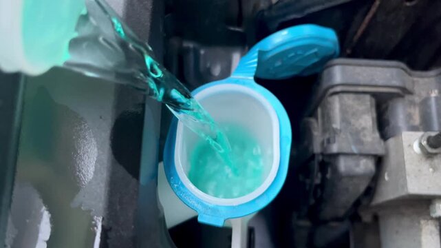 Close up view of green windshield washer fluid pouring