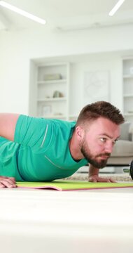 Man doing push ups on fitness mat at home