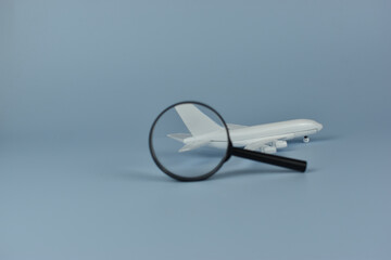 Fototapeta premium White model airplane sits under magnifying glass