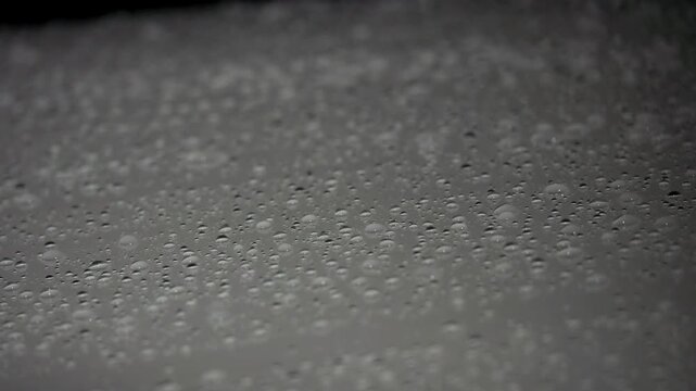 Tokyo, Japan - June 21, 2026: Raindrops falling on a Hood or a bonnet in the night
