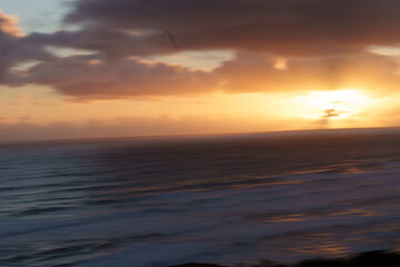 Obraz premium Bayleys and Ripiro Beach sunset deep blue cloud and waves rolling in on beach