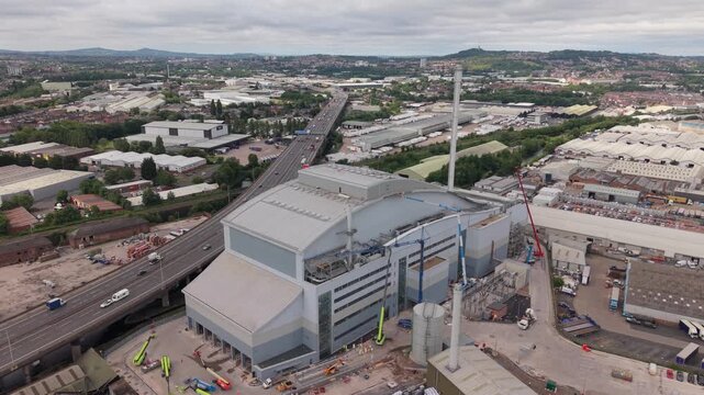 Drone aerial view of the Enfinium Kelvin Energy Recovery Facility alongside the M5 motorway in Oldbury, West Midlands, England. Large waste-to-energy infrastructure surrounded by warehouses