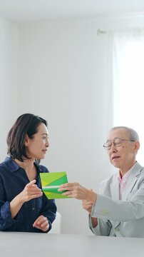 通帳を見て喜ぶ女性とシニア男性
