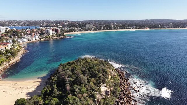 Aerial view of The Bower Manly featuring rocky headlands, sandy beach, and turquoise ocean waters along the coastline in Manly, New South Wales, Australia.