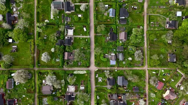 Aerial view of residential allotment gardens and houses with green plots and pathways in Helsinki, Uusimaa, Finland.