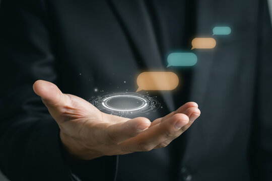Businessman holding a glowing virtual circle interface displaying empty chat bubbles, representing AI chat assistants, automated customer support, and online communication
