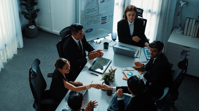 Top view of smart executive manager looking at financial graph while skilled business team give high five and clapping hands to celebrate increasing sales. Successful team shaking hands. Directorate.